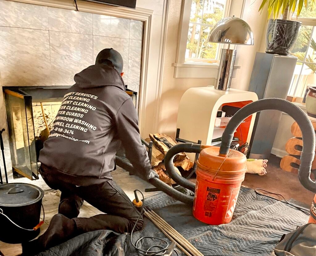 St. Nicks Chimney technician performing a 100% mess free chimney sweep using a Hepa vacuum system, power tools, and drop cloths.